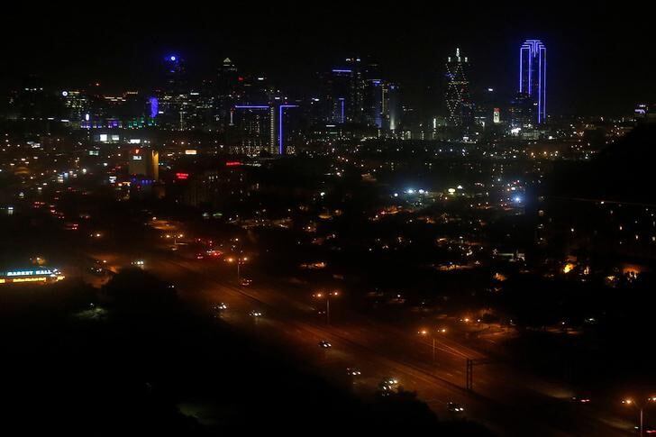 The skyline of Dallas is lit up in blue